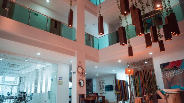 Een ruime lobby met een hoge plafond, grote ramen en een modern design.