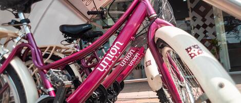 A pink bicycle with "Union" branding parked next to a white bicycle.