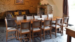 Comedor con pared de piedra, mesa y sillas de madera.