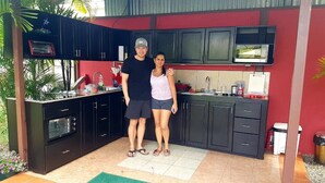 Una cocina compacta con armarios oscuros, un microondas integrado y una pequeña ventana sobre el fregadero.