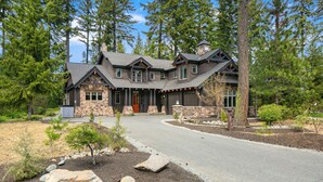 A two-story house with a stone facade, a wrap-around porch, and a driveway leading to the entrance. - Evergreen Escape Estates with lots of amenities ! AVAILABLE FOR LONG TERM  (Cle Elum)