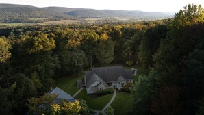 Une grande maison entourée d’une forêt dense, offrant une vue dégagée sur le paysage environnant.