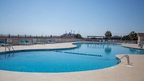 A swimming pool with lounge chairs and a lifeguard tower. - 143 By the Sea * Gated Myrtle Beach Resort * 2/2 (Horry County)