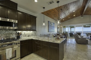A spacious kitchen with dark wood cabinets, stainless steel appliances, and a large island.