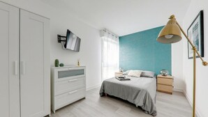 A bedroom with a bed, bedside tables, a wardrobe, a TV, and a lamp. - Apartment coup de coeur, 3 bedrooms, 10 minutes from Rouen, Netflix (Mont-Saint-Aignan)