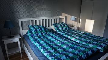 Una camera da letto con un letto, due comodini, una lampada e un armadio.
