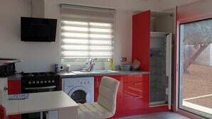 Cuina petita amb fornell, rentadora i rentaplat.