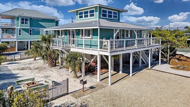 A coastal building with a balcony, a covered area, and a view of the beach.