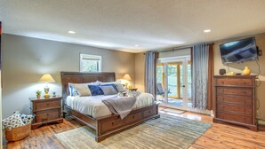 A bedroom with a bed, nightstands, a dresser, a television, and a view of the outdoors. - Casa Immaculata on Chalk Creek w/ Views! (Nathrop)
