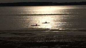 A calm body of water with a boat in the distance. - Charlottetown Hrbr’view Executive Waterfront (Stratford)