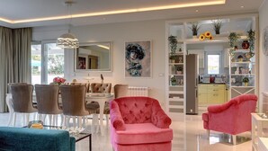 Una sala de estar moderna con comedor, cocina y vistas al exterior.