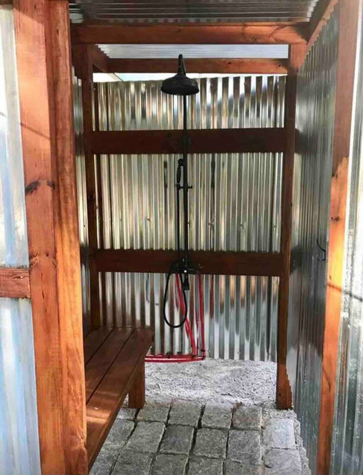 Un espacio al aire libre cubierto con un banco de madera y una estructura de metal.
