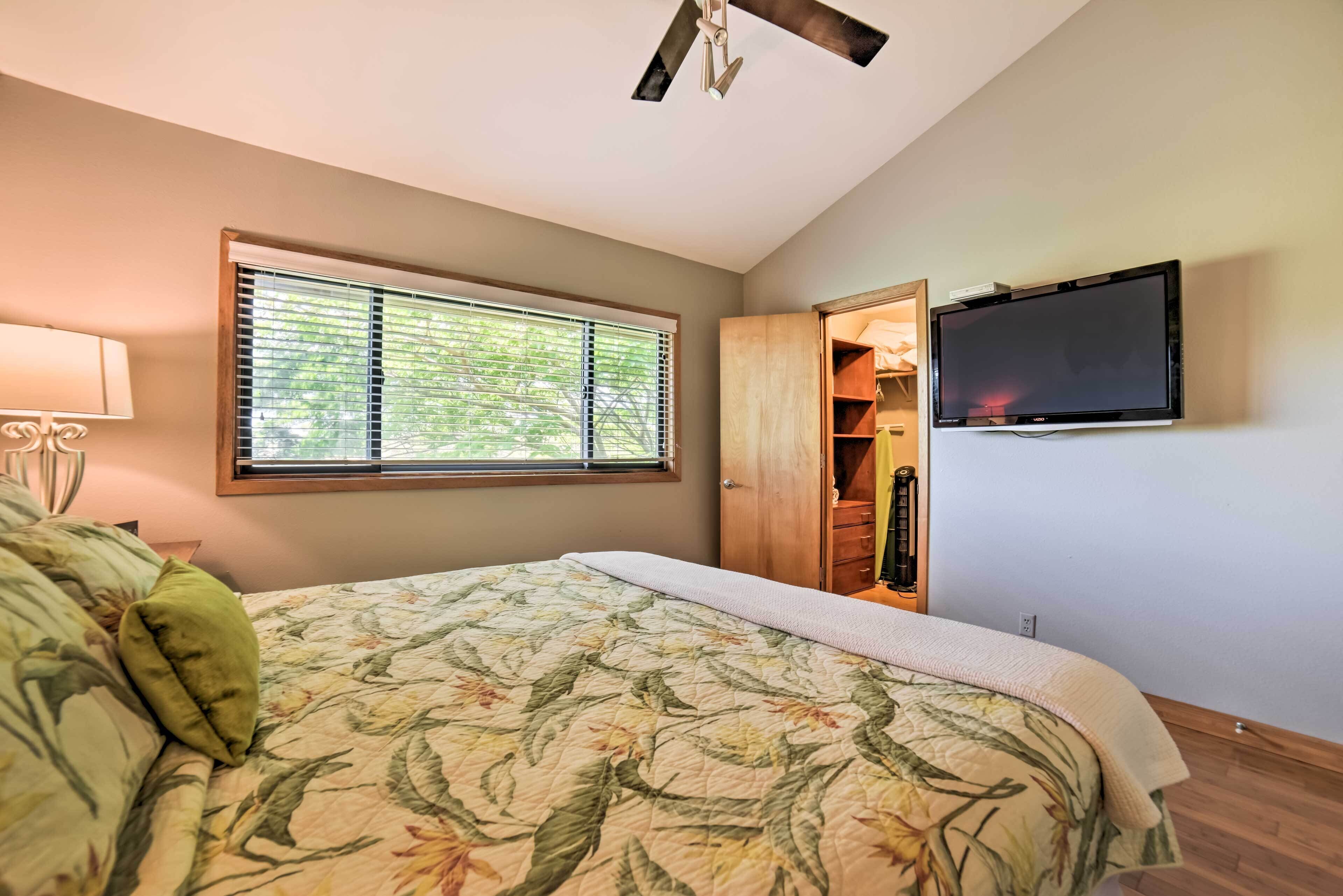 Une chambre à coucher avec un lit, une fenêtre, une armoire et un téléviseur.