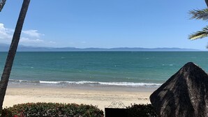 A beach with clear blue water, palm trees, and a thatched structure. - Spectacular Casa Coco, Private Beachfront Villa in Vallarta/Bucerias, Mexico (Bucerías)