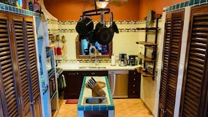 A kitchen with a central island, wooden cabinets, and a tiled floor. - Spectacular Casa Coco, Private Beachfront Villa in Vallarta/Bucerias, Mexico (Bucerías)