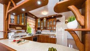 Une cuisine moderne avec des meubles en bois, un plan de travail en marbre et un réfrigérateur blanc.