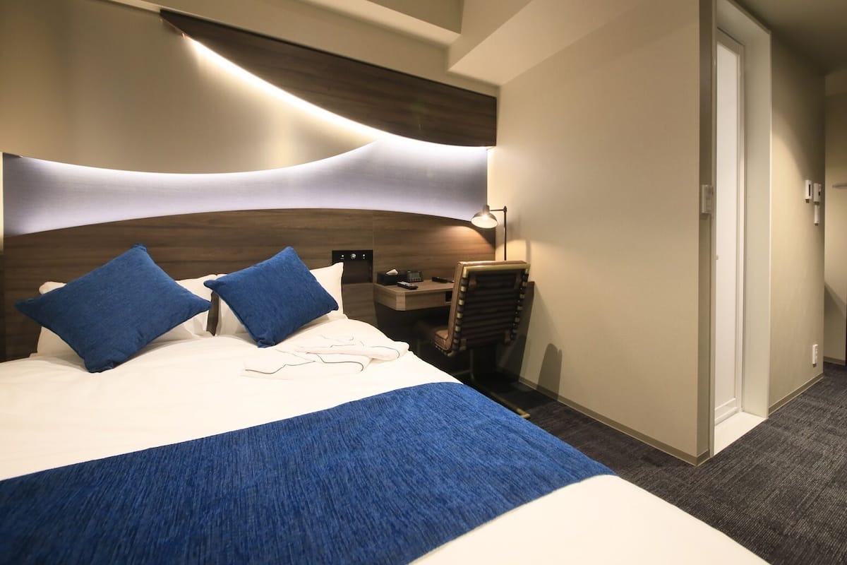 Une chambre d’hôtel avec un grand lit, un bureau et une chaise.