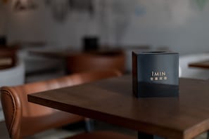 Een zwarte doos met gouden letters op een houten tafel in een restaurant.