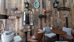 Ein gemütliches Interieur mit Holzwänden, einem Vintage-Spiegel und einem einladenden Schild.