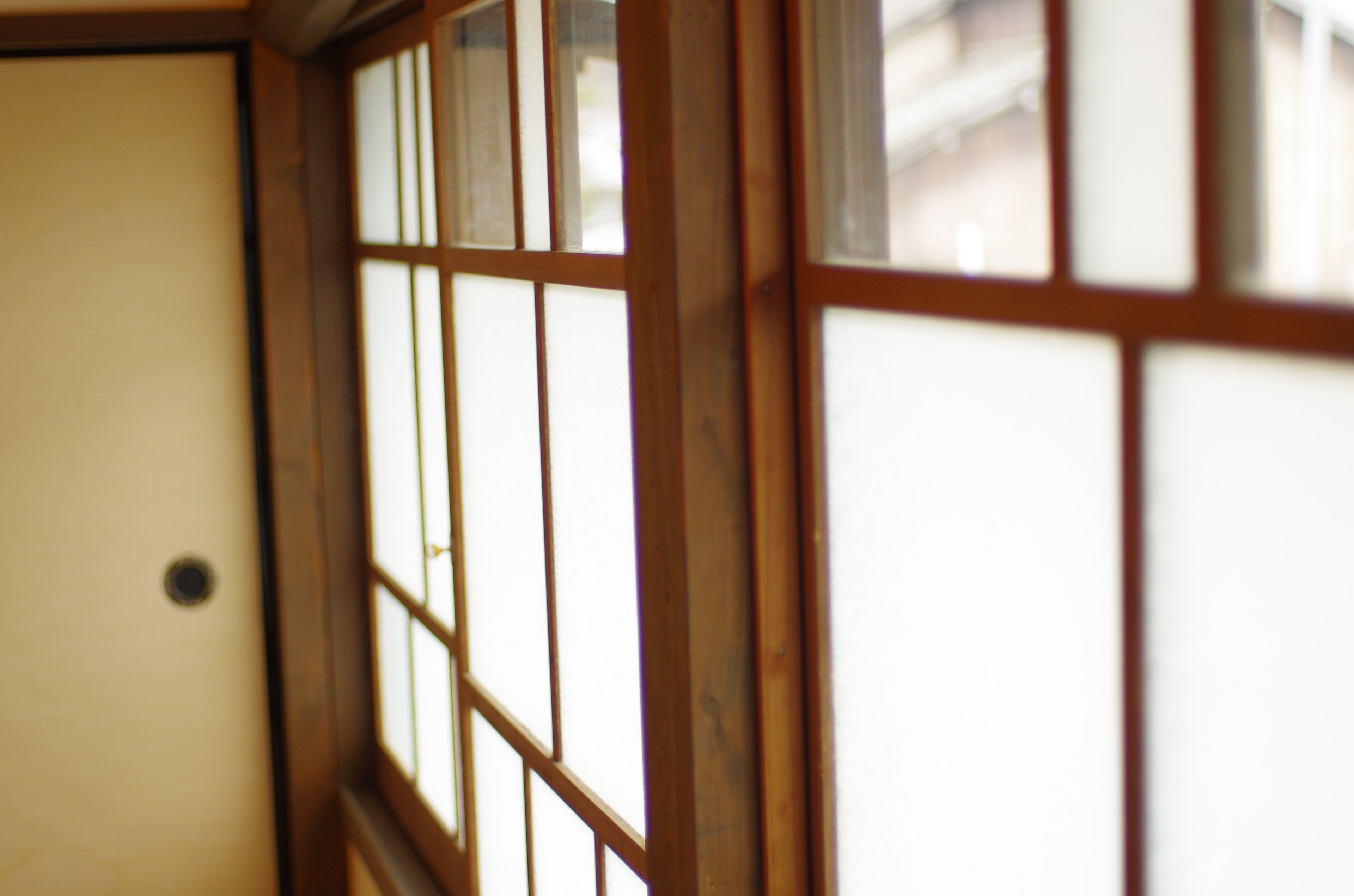 A traditional Japanese room with wooden sliding doors and a white wall.