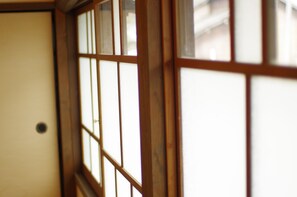 A traditional Japanese room with wooden sliding doors and a white wall. - Akitsukikominkaryokan You (Asakura)