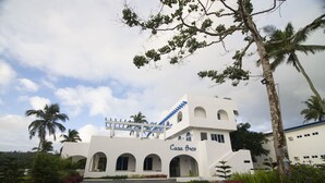 A white building with the name "Casa Arco" and a staircase leading to the upper level.