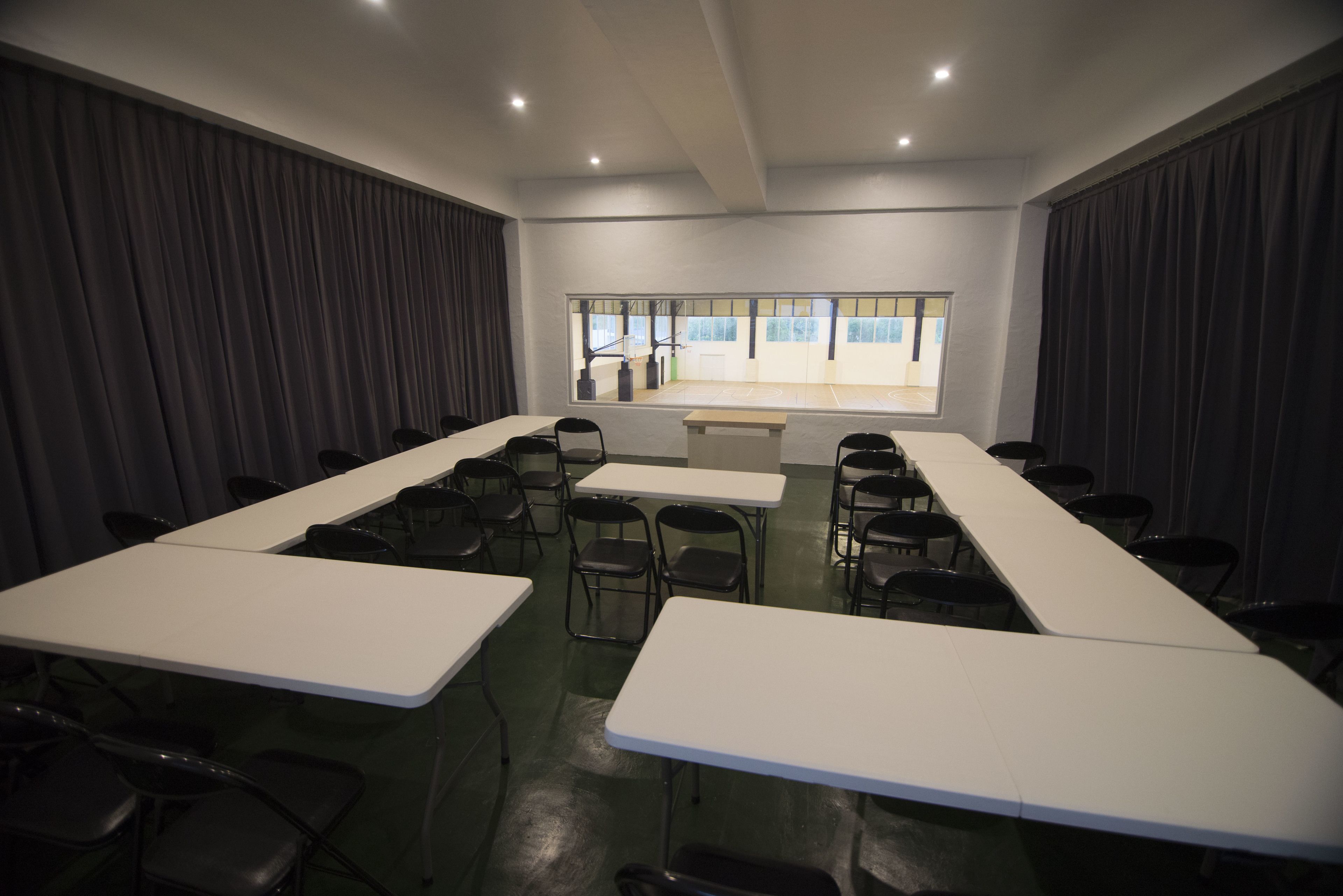 A conference room with a long table, chairs, and a large window.