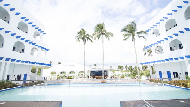 A pool area with a clear view of the resort's architecture, including multiple levels with balconies and a central building labeled "RESORT CENTER".