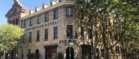 The exterior of the Ord Nelson Hotel, featuring a brick facade, large windows, and a sign indicating it is a brewery.