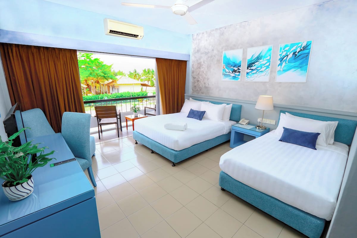 A hotel room with two beds, a desk, a chair, a potted plant, and artwork on the wall.