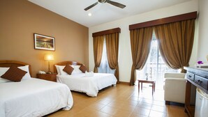 A hotel room with two beds, a desk, a chair, a ceiling fan, and a window with curtains. - Villea Morib (Banting)