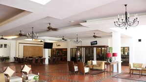 A spacious lobby with a coffee house, comfortable seating areas, and a modern chandelier. - Villea Morib (Banting)