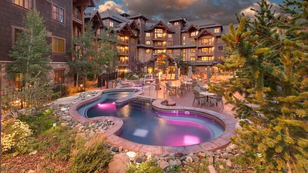 A lodge with a pool area, outdoor seating, and a mountainous backdrop. - 2 Bd Grand Lodge Peak 7 - sleeps 8 (Breckenridge)