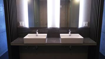 Een badkamer met twee wasbakken, een spiegel en een marmeren aanrechtblad.