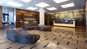 A modern lobby with a reception desk, seating area, and a large wall mural. - Hotel Forza Kanazawa (Kanazawa)