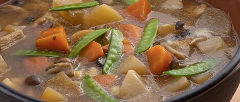 A close-up of a stew with various vegetables and meat in a pot.