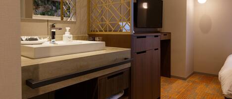 A modern bathroom with a large sink, mirror, and wooden cabinet.