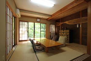 A traditional Japanese room with tatami flooring, a wooden dining table, and sliding shoji doors.