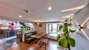 A modern interior with a wooden floor, a green sofa, a dining table, and a staircase. - Sucha Hotel Chongqing Danzishi Laojie (Chongqing)