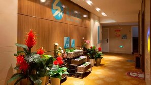 A reception area with a wooden wall, a sign for the SICHUAN HOTEL, and potted plants. - Sucha Hotel Chongqing Danzishi Laojie (Chongqing)