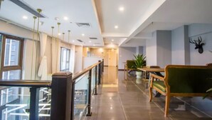 A hotel lobby with a glass railing, a staircase, a reception desk, and a deer head decoration. - Sucha Hotel Chongqing Danzishi Laojie (Chongqing)