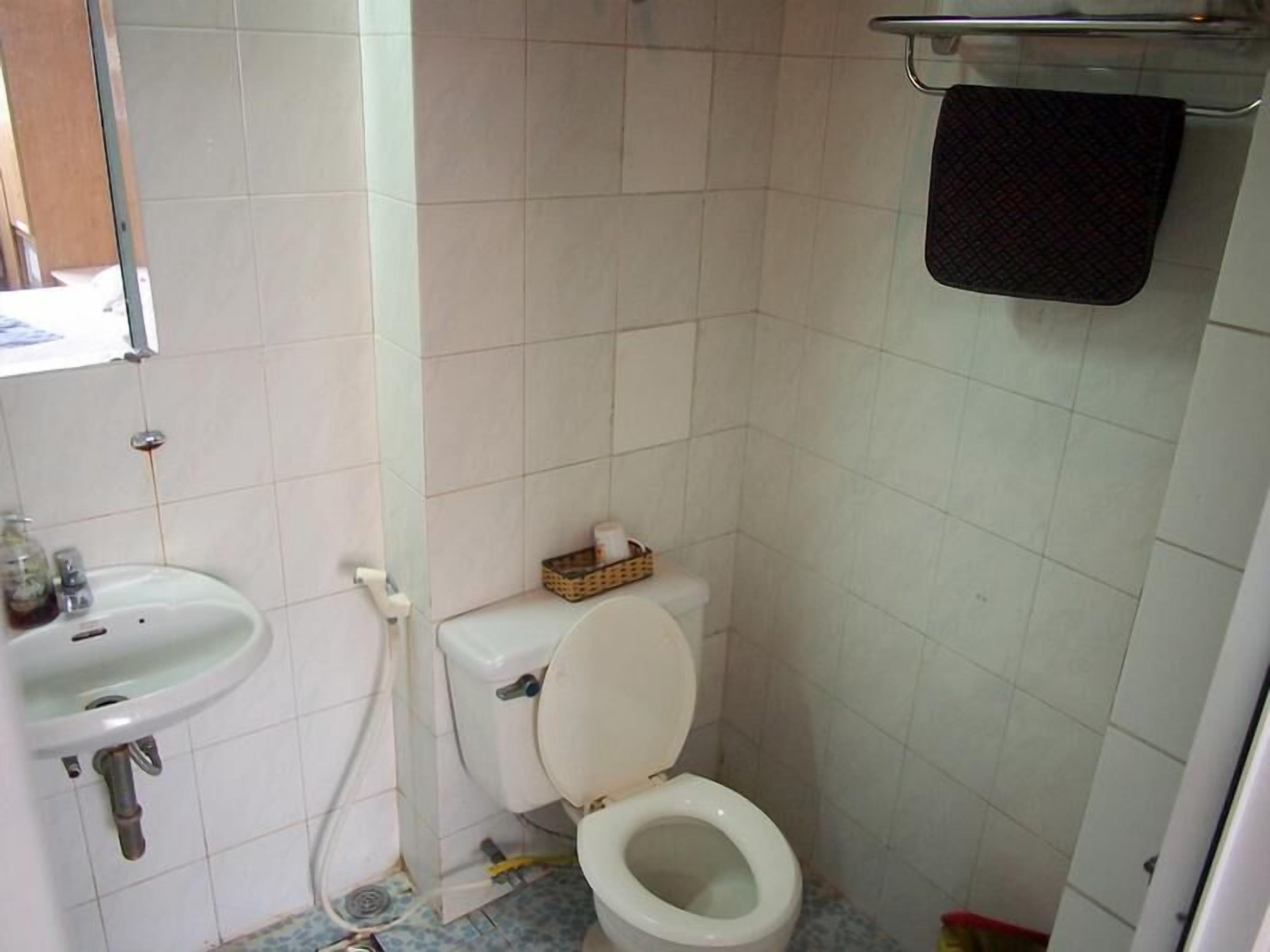 A small bathroom with a toilet, sink, and a towel rack.