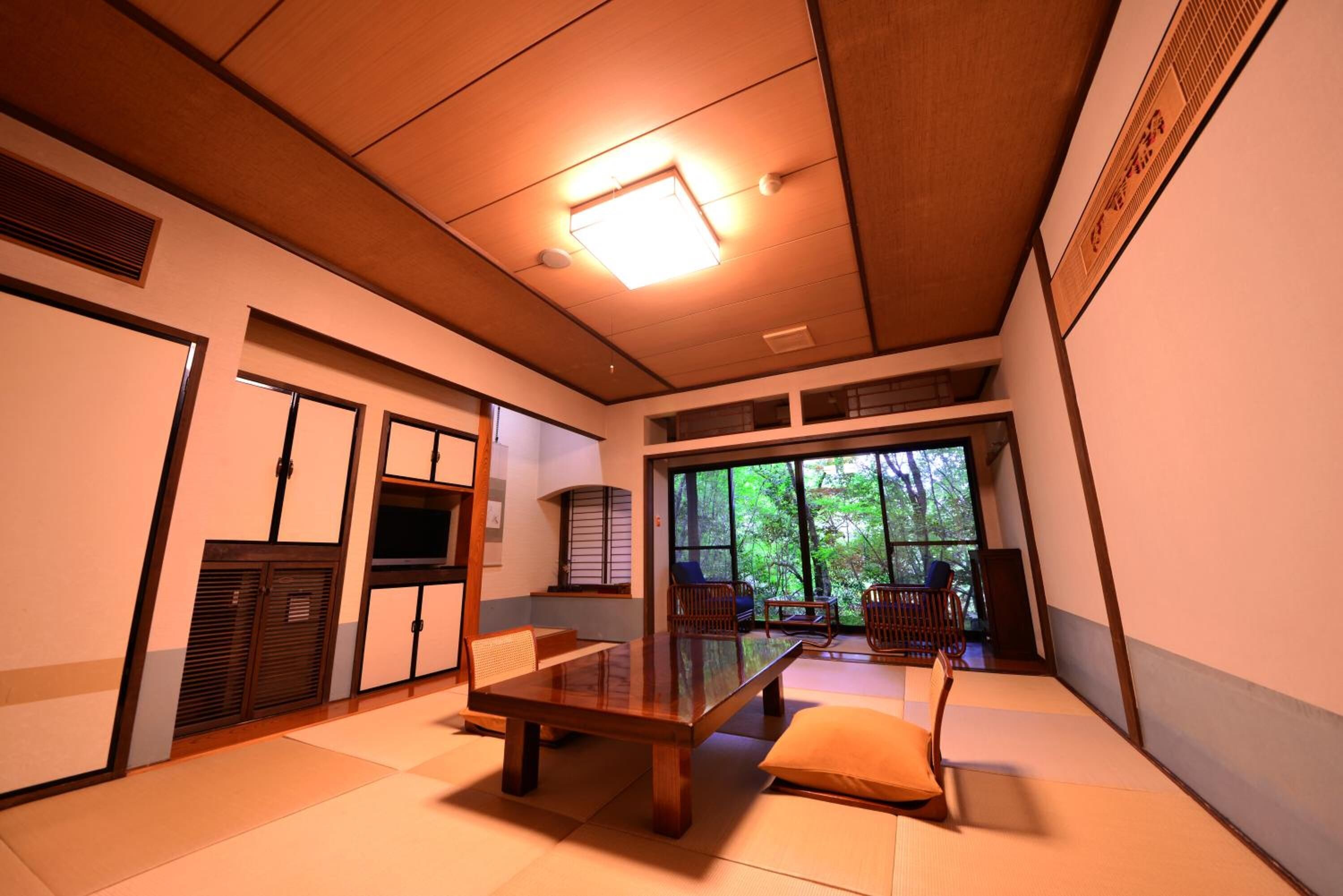 A traditional Japanese room with tatami flooring, a low wooden table, and sliding doors.
