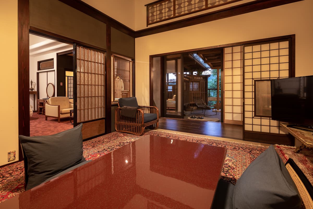 A traditional Japanese-style room with tatami flooring, a low table, and a television.