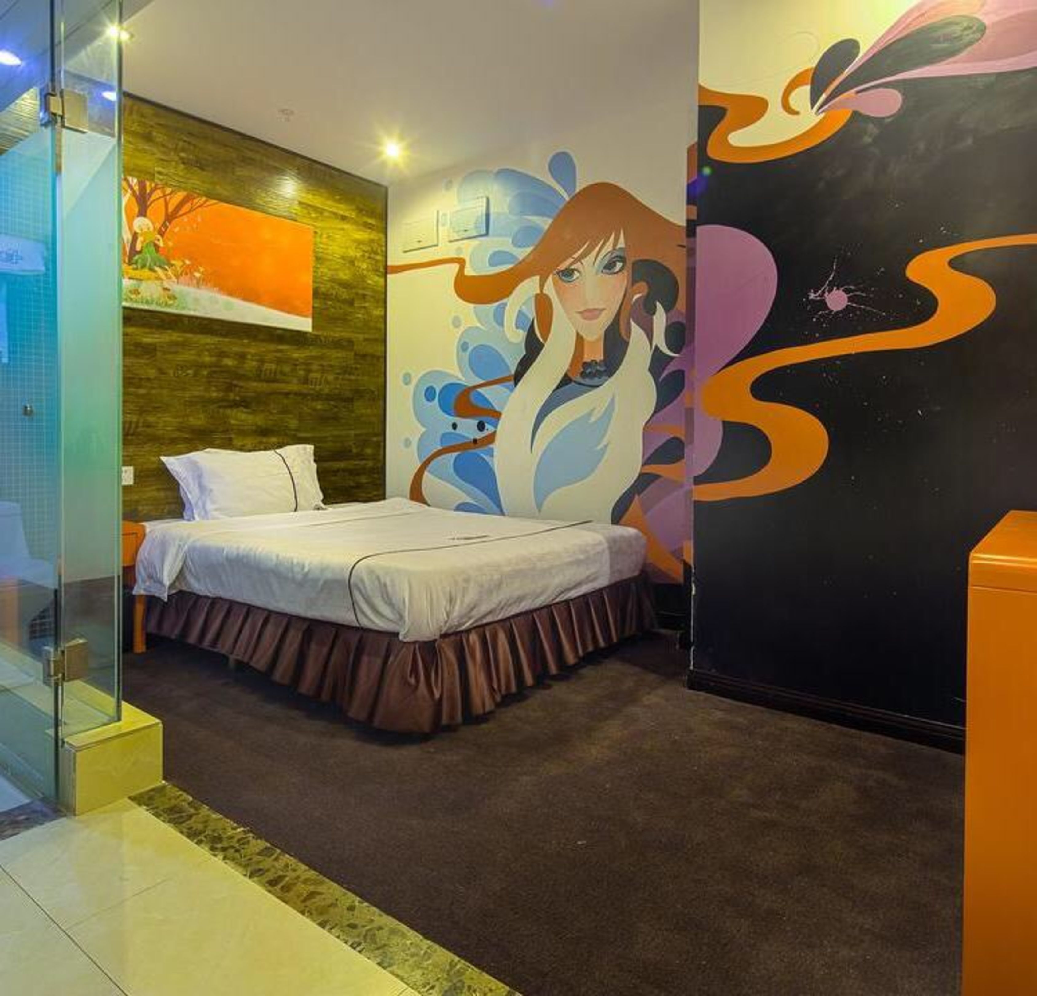 A modern bedroom with a bed, a glass partition, and a mural on the wall.