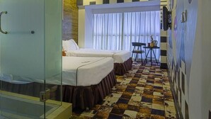 Une chambre d’hôtel avec deux lits, une cloison en verre, un sol à carreaux et une fenêtre avec des rideaux.