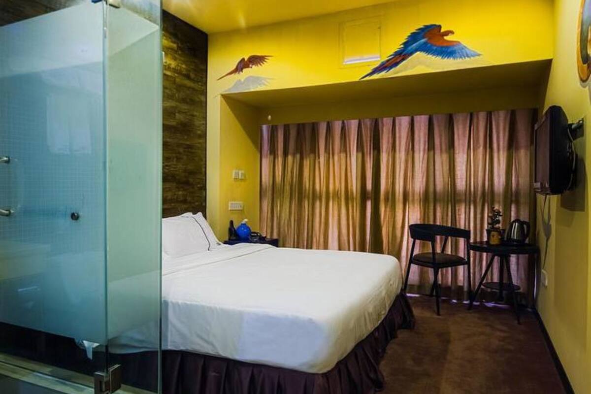 Une chambre d’hôtel équipée d’un lit, d’un bureau, d’une chaise et d’un téléviseur.