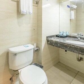 A bathroom with a toilet, a sink with a marble countertop, and a mirror above the sink. - Sucha Hotel Chongqing North Station (Chongqing)