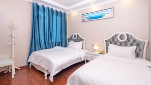 A hotel room with two beds, a nightstand with a lamp, a painting on the wall, and a blue curtain.