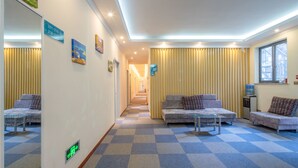 A hotel lobby with checkered flooring, two sofas, a water dispenser, and a staircase in the background. - Sucha Hotel Chengdu Wuhouci Jinli (Chengdu)